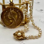 Collar de perlas con virgen y broche flor